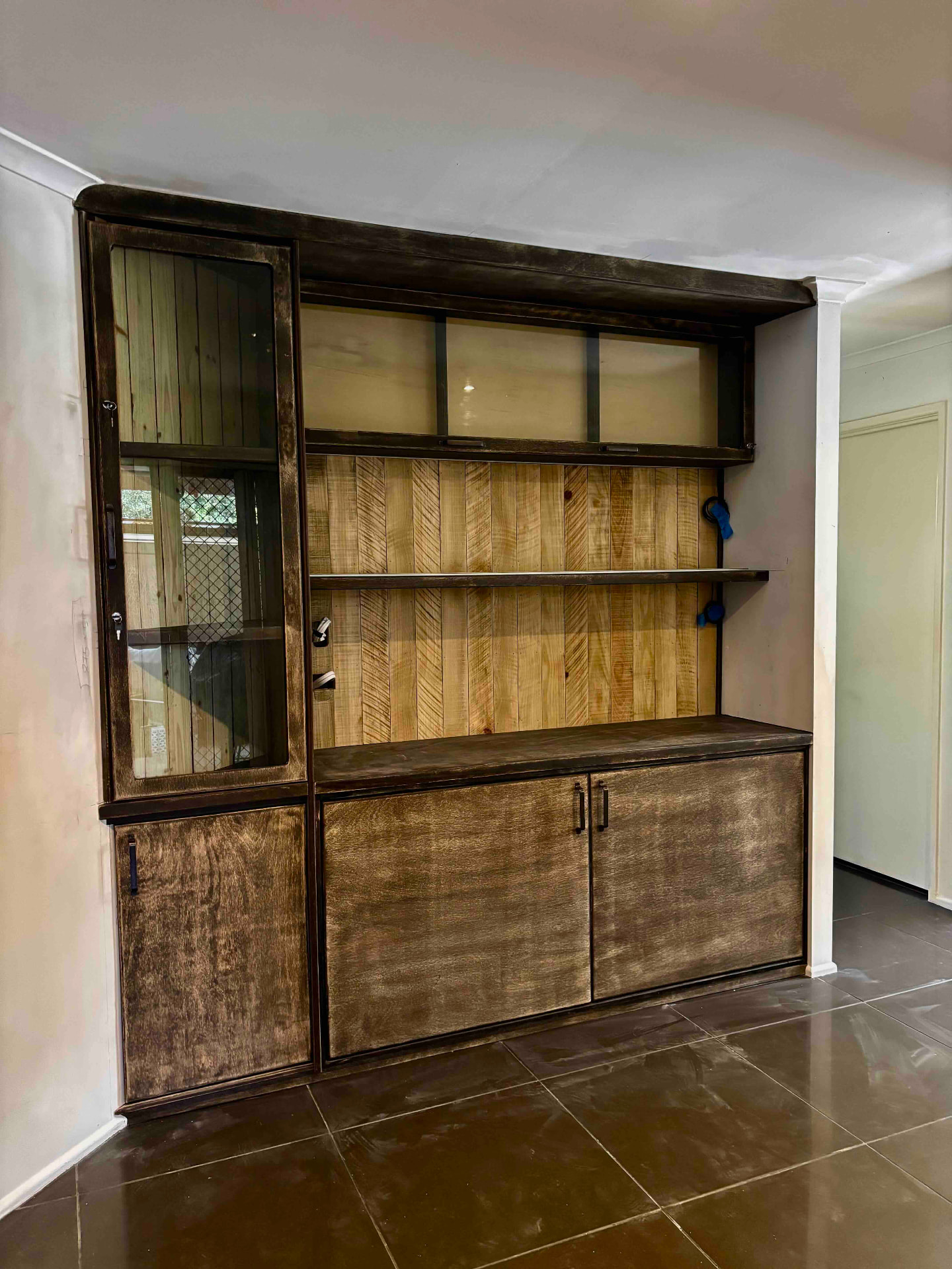 Rustic dark stained timber drinks bar with lockable glazed cabinets and herringbone timber back panel
