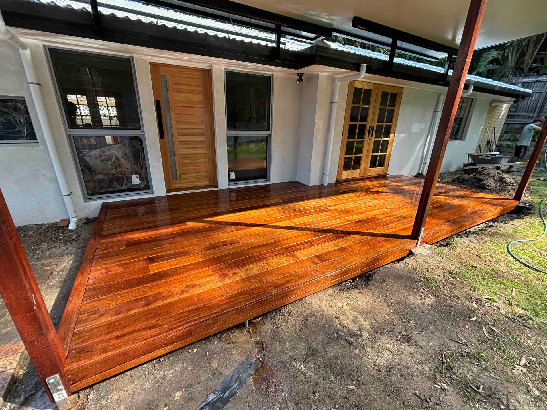 Freshly oiled hardwood entry deck built around new timber doors